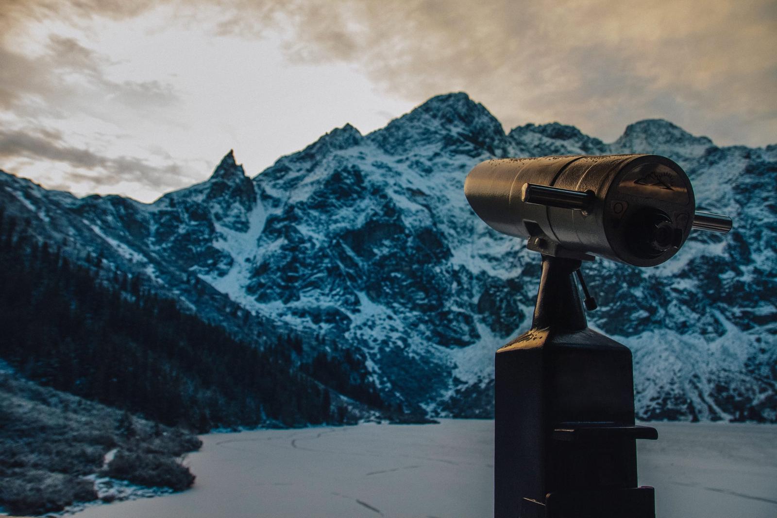 Fernrohr mit Blick auf verschneite Berge